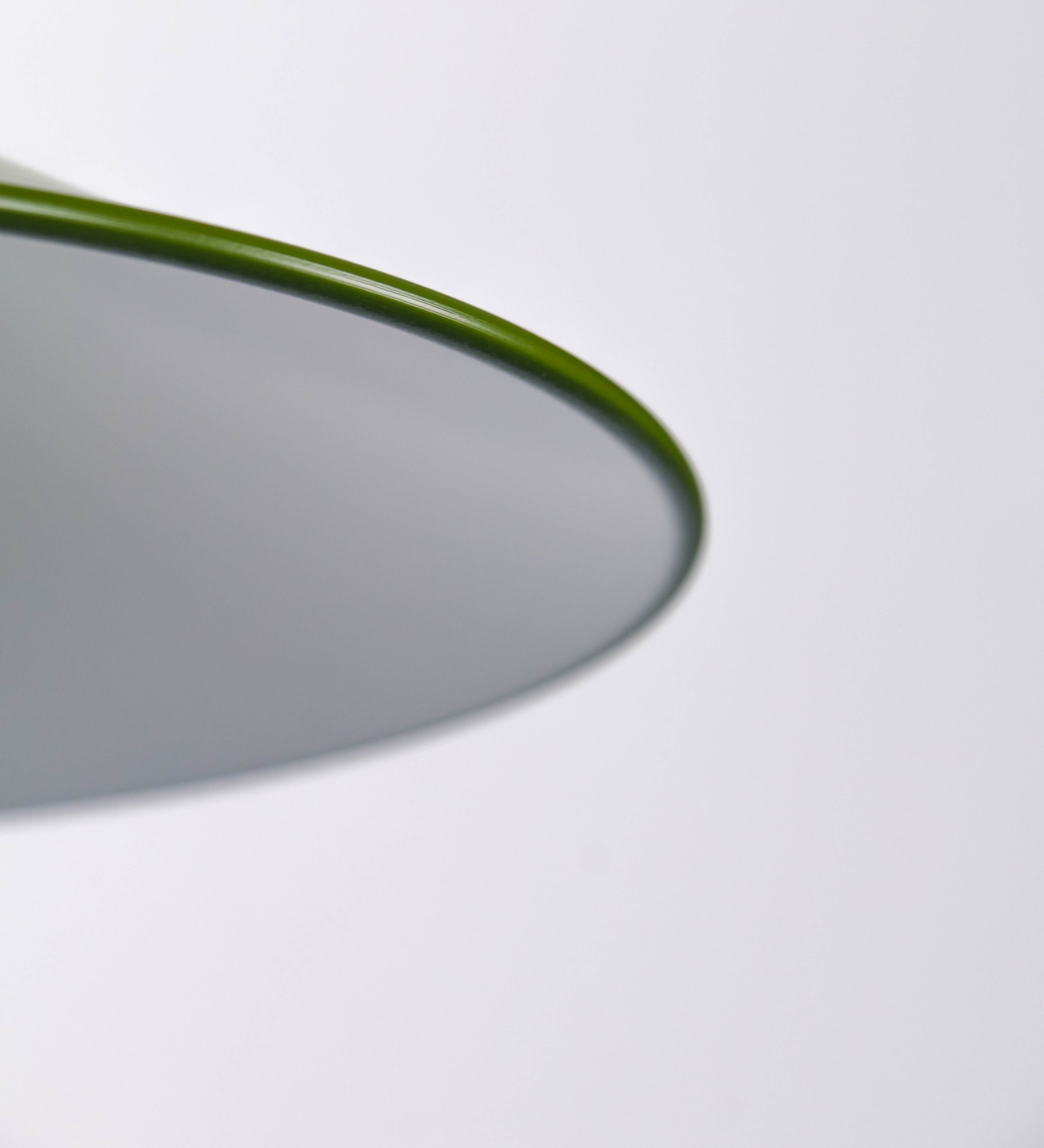 Aplique de parede com um design clássico e cores contemporâneas. O aplique é composto por uma base circular verde couve-de-bruxelas, de onde se estende um braço curvo, que forma um arco gracioso e sustenta o chapéu do candeeiro, verde também. O chapéu tem um formato cónico invertido, com uma borda ligeiramente levantada, que direciona a luz para baixo. O interior do chapéu é branco. No topo do chapéu, há um suporte circular em níquel escovado, com três braços que fixa o chapéu ao braço curvo.