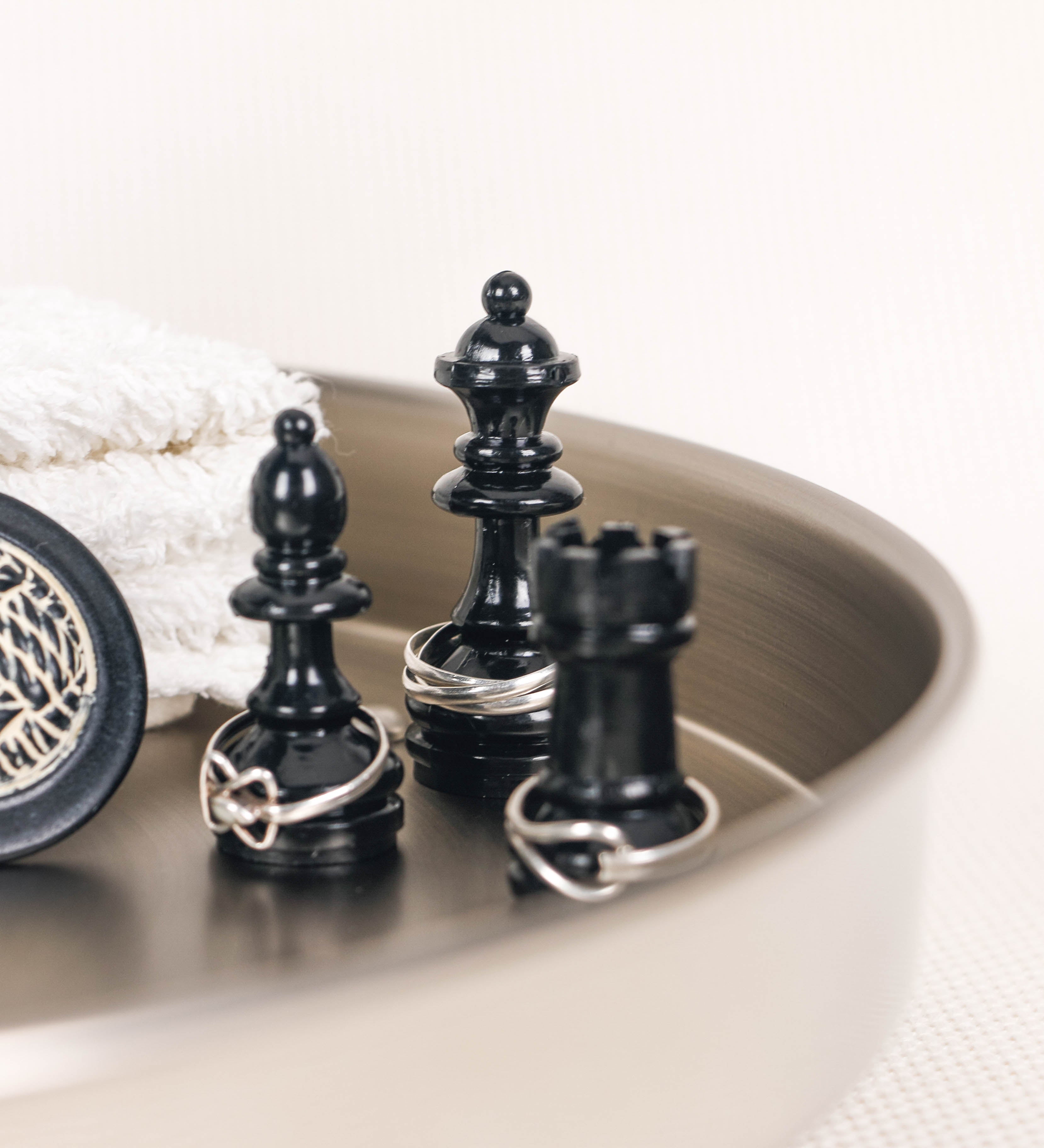 Bandeja com um design sofisticado e intemporal. A bandeja é de latão, tendo na superfície exterior um acabamento em tom prateado e com efeito de espelho, e um acabamento em tom prateado com efeito mate na superfície interior. Tem uma forma circular, de superfície plana e com uma borda envolvente de altura média e grossura fina. Na sua base tem três pequenas esferas, em níquel polido também, dispostas em formato triangular, que sustentam o prato circular no topo.