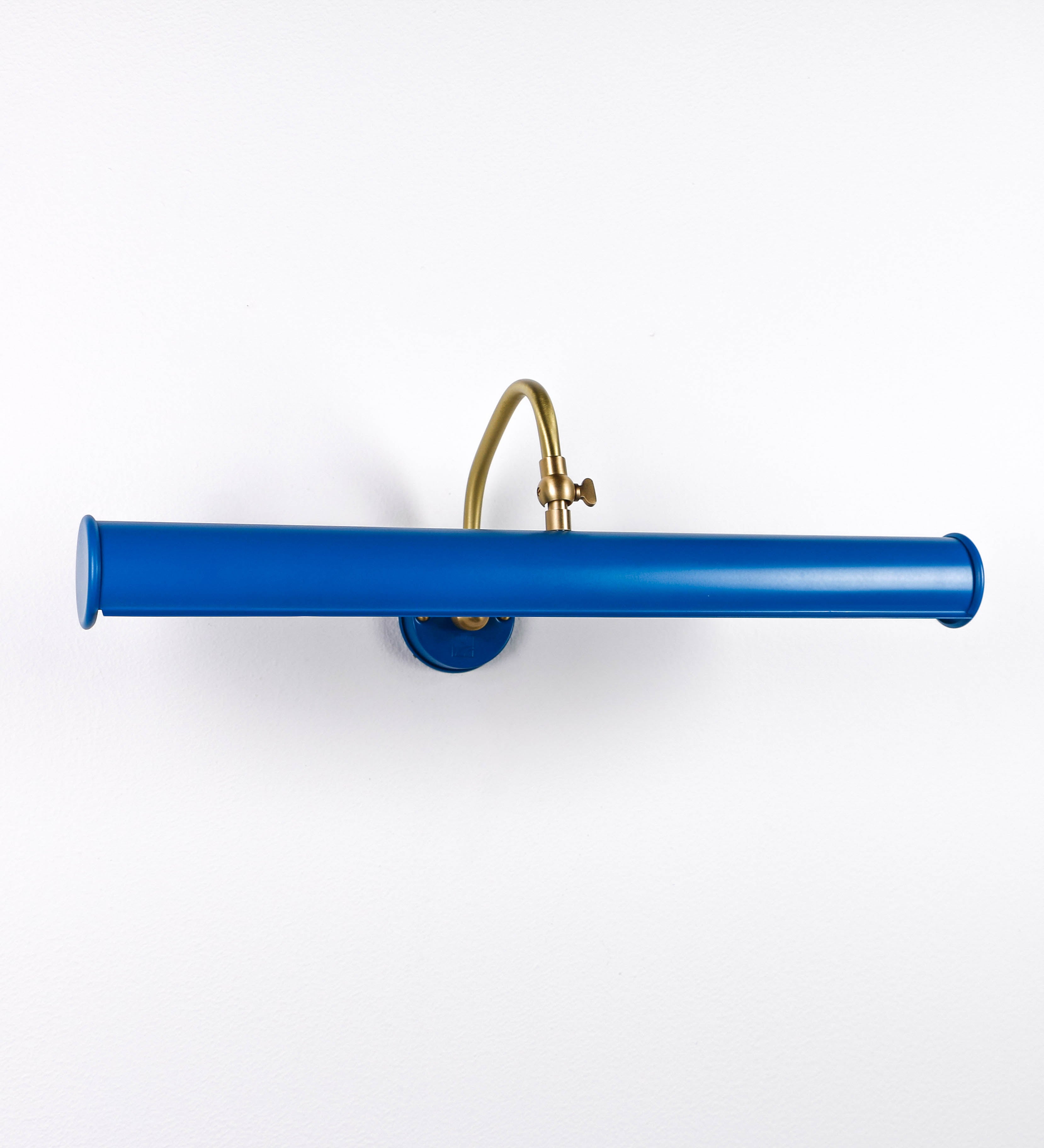 Aplique de parede que combina elementos clássicos com toques contemporâneos. O aplique é composto por uma base circular azul vintage de onde se estende um braço curvo e gracioso, em latão escovado, que suporta a barra principal. O braço contém um elemento, em latão escovado, que permite apertar ou desapertar a barra para melhor manipular a direção da luz. A barra de 45cm de largura, é cilíndrica e alongada, azul vintage. As extremidades do cilindro são planas e do mesmo diâmetro.