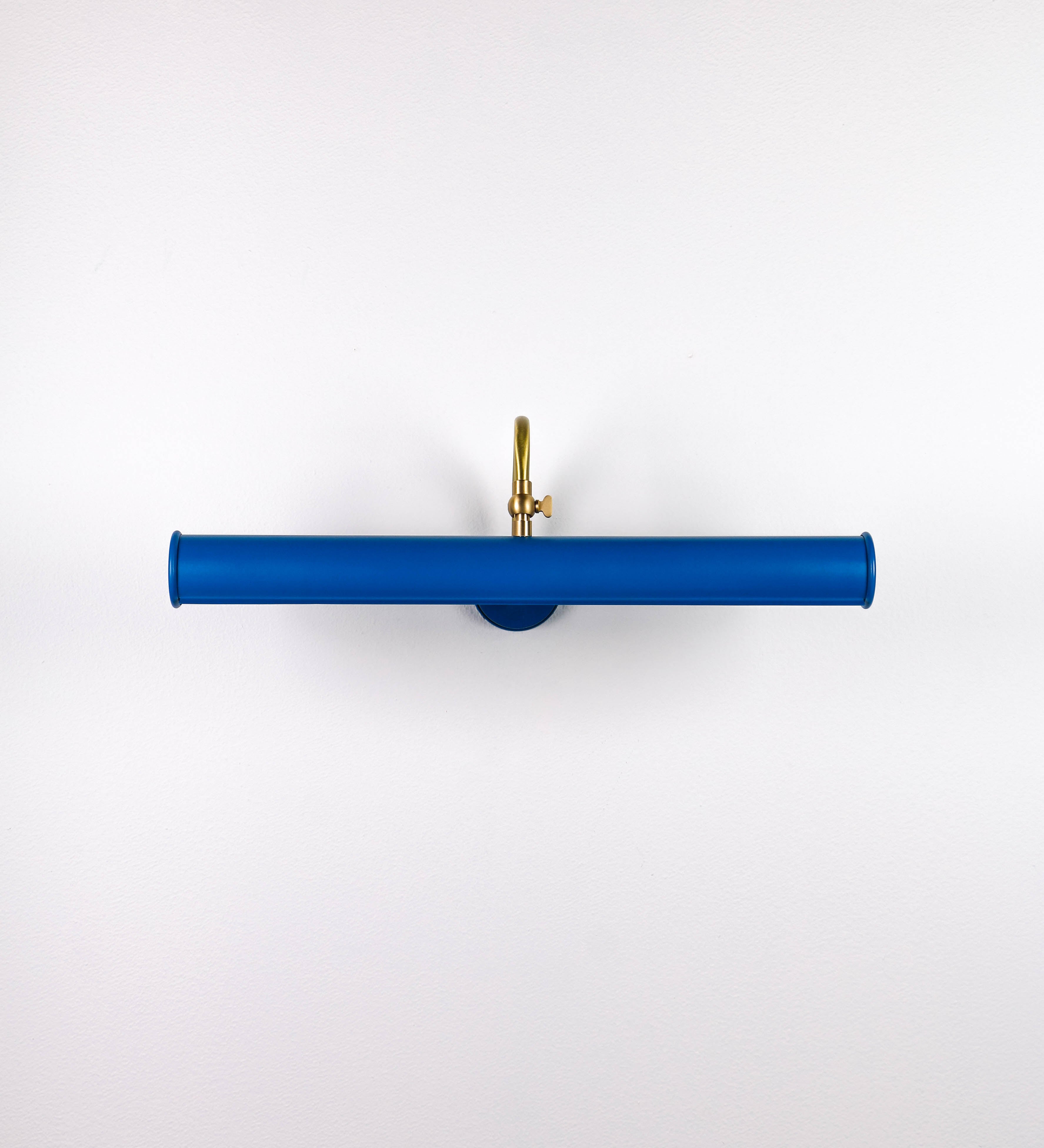 Aplique de parede que combina elementos clássicos com toques contemporâneos. O aplique é composto por uma base circular azul vintage de onde se estende um braço curvo e gracioso, em latão escovado, que suporta a barra principal. O braço contém um elemento, em latão escovado, que permite apertar ou desapertar a barra para melhor manipular a direção da luz. A barra de 45cm de largura, é cilíndrica e alongada, azul vintage. As extremidades do cilindro são planas e do mesmo diâmetro.
