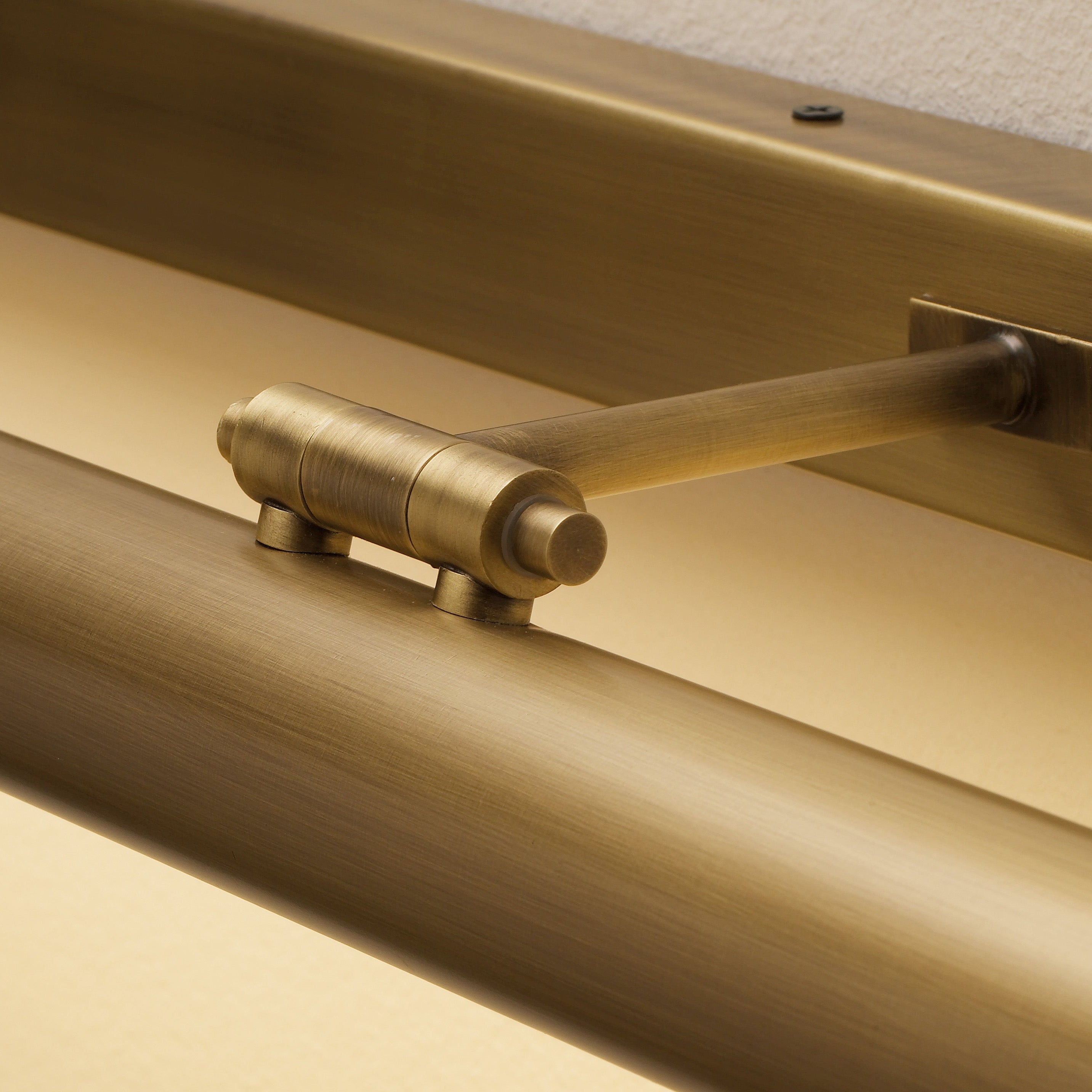 Detalhe em close-up de um candeeiro em latão produzido pela Lustrarte, mostrando o acabamento e a articulação da peça.