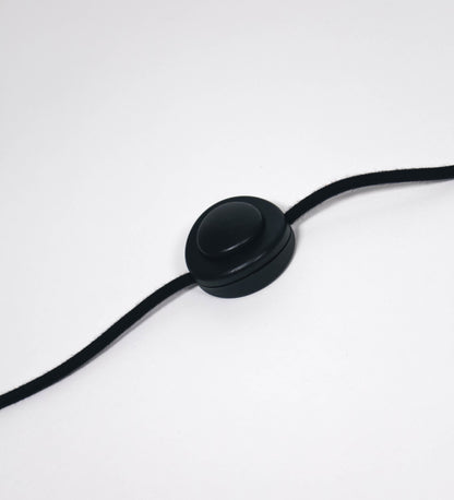 Cabo revestido têxtil em preto, com um interruptor de pé preto circular.