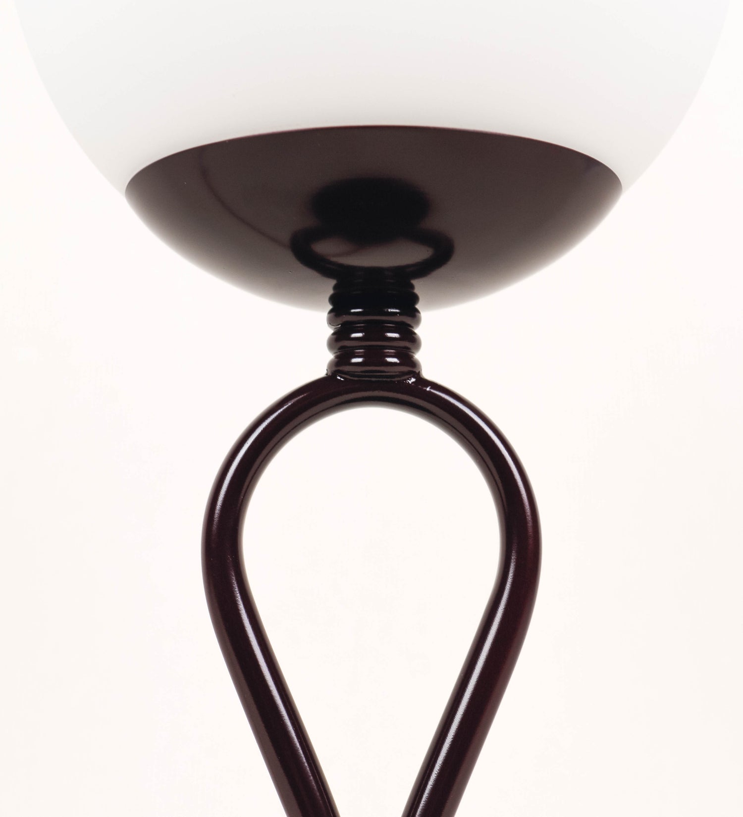 Candeeiro de mesa com um design clássico e sofisticado. O candeeiro possui uma base circular e robusta de tom vinho. A estrutura da base é complementada por um suporte em forma de nó, também de tom vinho, que se eleva graciosamente até ao suporte da luz. A luz é difundida através de uma esfera de vidro fosco branco, assente no corpo. O cabo é revestido têxtil de tom rosa velho, com interruptor e ficha transparentes.