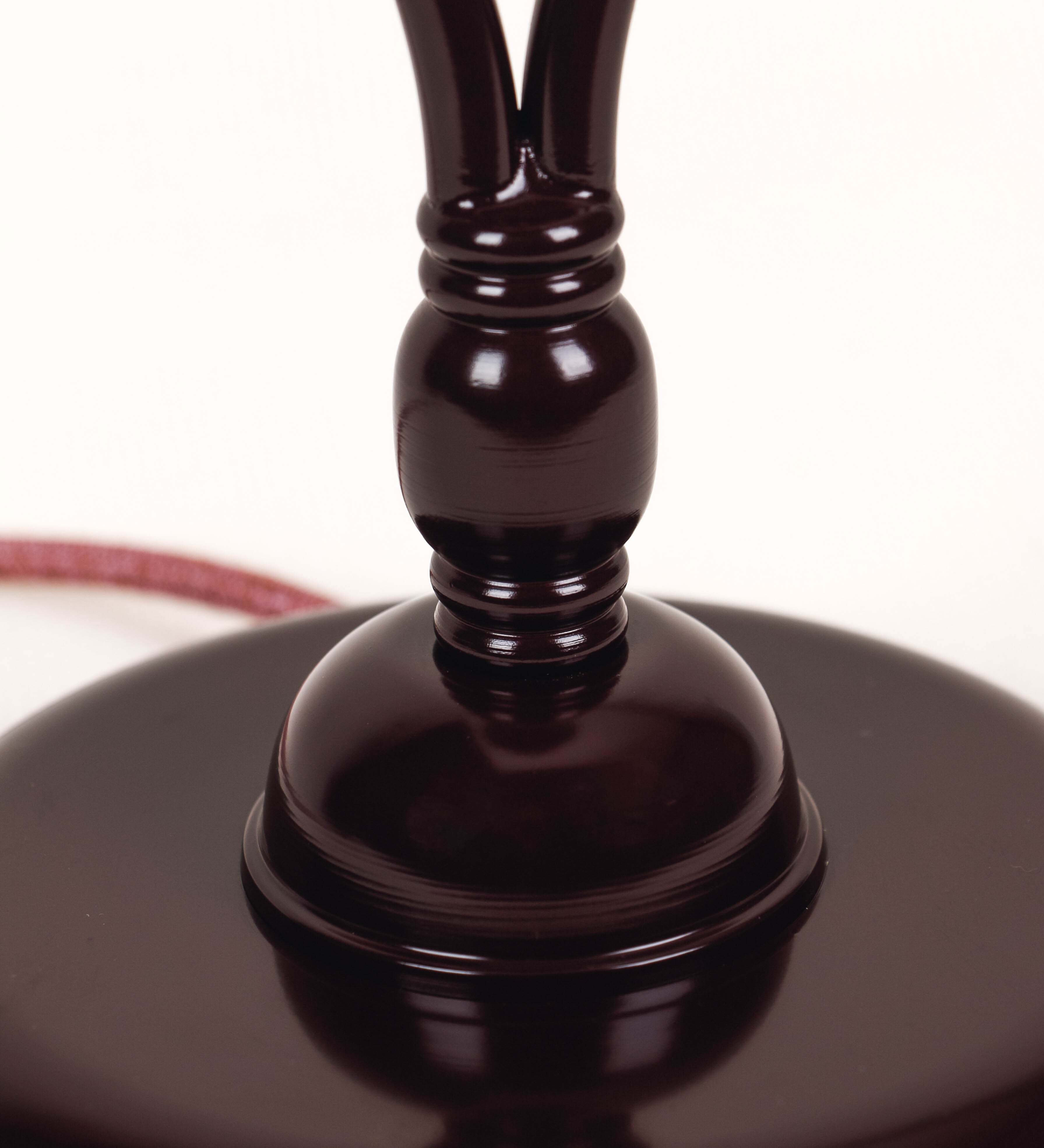 Candeeiro de mesa com um design clássico e sofisticado. O candeeiro possui uma base circular e robusta de tom vinho. A estrutura da base é complementada por um suporte em forma de nó, também de tom vinho, que se eleva graciosamente até ao suporte da luz. A luz é difundida através de uma esfera de vidro fosco branco, assente no corpo. O cabo é revestido têxtil de tom rosa velho, com interruptor e ficha transparentes.
