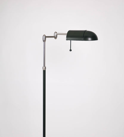 Candeeiro de pé com base circular em verde-azeitona. O corpo é fino e vertical, composto por uma haste verde-azeitona, e uma outra haste em níquel escovado, que permite ajustar a altura do candeeiro. A haste ajustável conecta a um braço horizontal, que sustenta o chapéu, e é manipulável. O chapéu é longo e arredondado, em verde-azeitona, e com uma pequena haste com uma esfera na ponta. O interior do chapéu é branco. O cabo é revestido têxtil em preto, com um interruptor de pé preto circular.