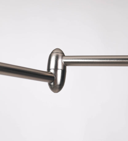 Candeeiro de pé com base circular em verde-azeitona. O corpo é fino e vertical, composto por uma haste verde-azeitona, e uma outra haste em níquel escovado, que permite ajustar a altura do candeeiro. A haste ajustável conecta a um braço horizontal, que sustenta o chapéu, e é manipulável. O chapéu é longo e arredondado, em verde-azeitona, e com uma pequena haste com uma esfera na ponta. O interior do chapéu é branco. O cabo é revestido têxtil em preto, com um interruptor de pé preto circular.