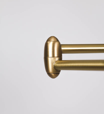 Candeeiro de pé com base circular em tom vinho. O corpo é fino e vertical, composto por uma haste tom vinho, e uma outra haste em latão escovado, que permite ajustar a altura do candeeiro. A haste ajustável conecta a um braço horizontal, que sustenta o chapéu, e é manipulável. O chapéu é longo e arredondado, em tom vinho, e com uma pequena haste com uma esfera na ponta. O interior do chapéu é branco. O cabo é revestido têxtil em preto, com um interruptor de pé preto circular.