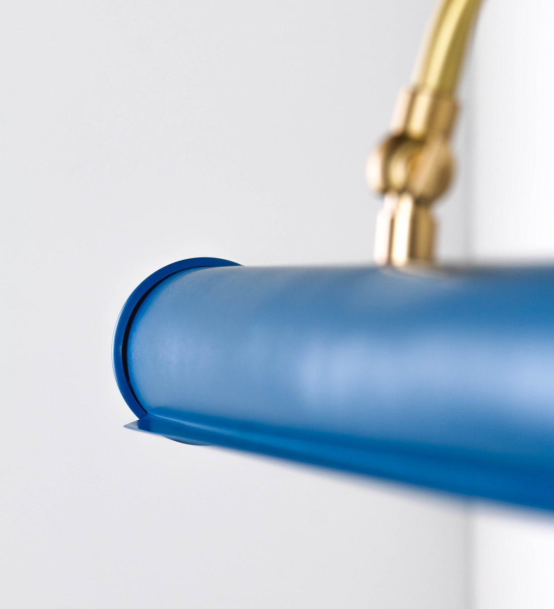 Aplique de parede que combina elementos clássicos com toques contemporâneos. O aplique é composto por uma base circular azul vintage de onde se estende um braço curvo e gracioso, em latão escovado, que suporta a barra principal. O braço contém um elemento, em latão escovado, que permite apertar ou desapertar a barra para melhor manipular a direção da luz. A barra de 45cm de largura, é cilíndrica e alongada, azul vintage. As extremidades do cilindro são planas e do mesmo diâmetro.