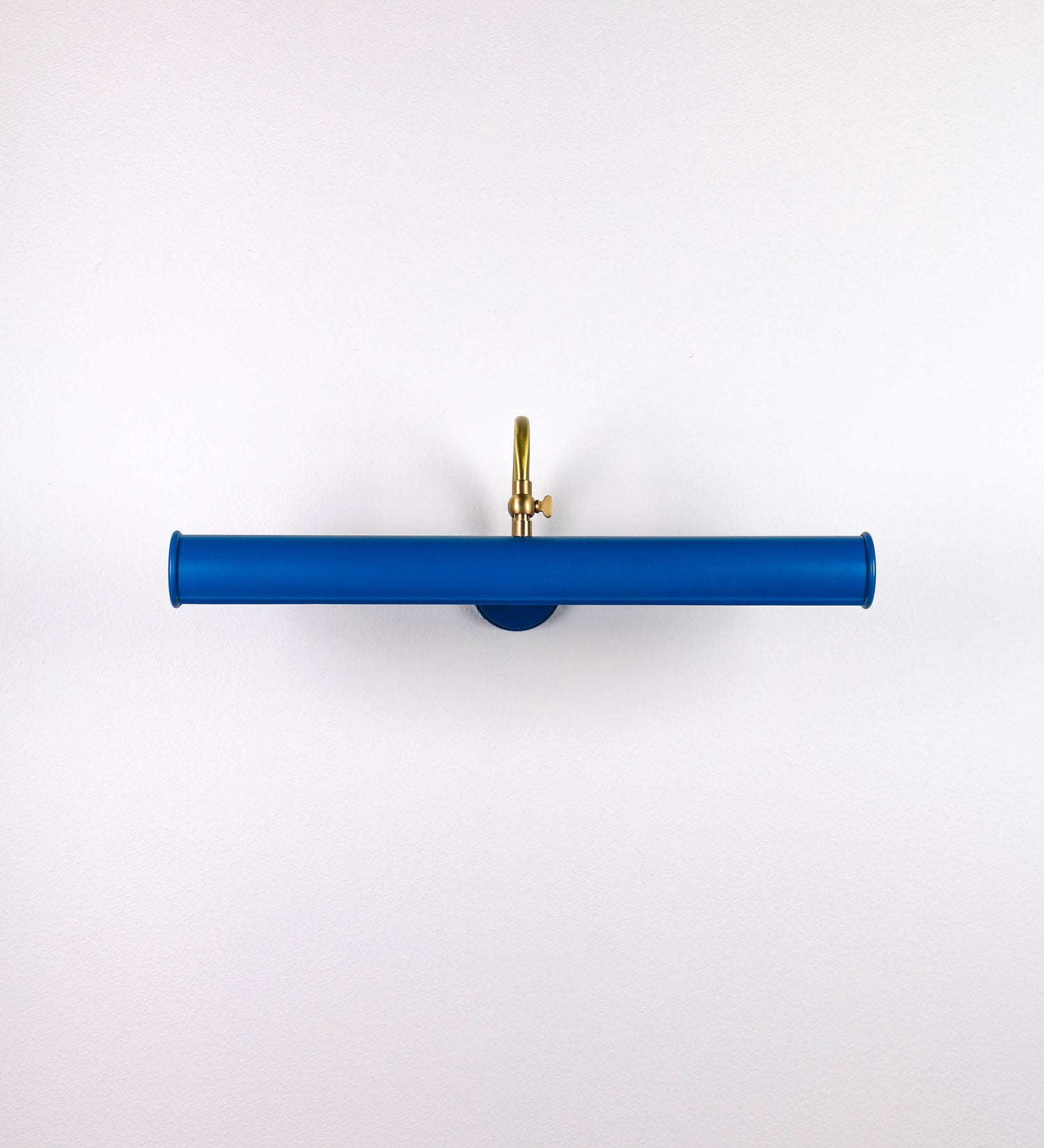 Aplique de parede que combina elementos clássicos com toques contemporâneos. O aplique é composto por uma base circular azul vintage de onde se estende um braço curvo e gracioso, em latão escovado, que suporta a barra principal. O braço contém um elemento, em latão escovado, que permite apertar ou desapertar a barra para melhor manipular a direção da luz. A barra de 45cm de largura, é cilíndrica e alongada, azul vintage. As extremidades do cilindro são planas e do mesmo diâmetro.
