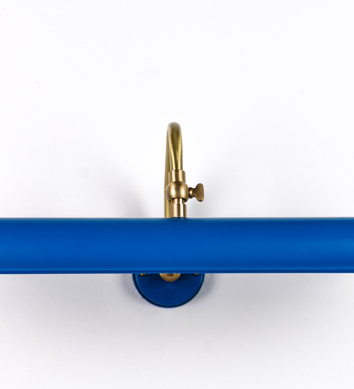 Aplique de parede que combina elementos clássicos com toques contemporâneos. O aplique é composto por uma base circular azul vintage de onde se estende um braço curvo e gracioso, em latão escovado, que suporta a barra principal. O braço contém um elemento, em latão escovado, que permite apertar ou desapertar a barra para melhor manipular a direção da luz. A barra de 45cm de largura, é cilíndrica e alongada, azul vintage. As extremidades do cilindro são planas e do mesmo diâmetro.