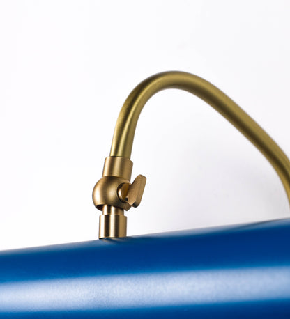 Aplique de parede que combina elementos clássicos com toques contemporâneos. O aplique é composto por uma base circular azul vintage de onde se estende um braço curvo e gracioso, em latão escovado, que suporta a barra principal. O braço contém um elemento, em latão escovado, que permite apertar ou desapertar a barra para melhor manipular a direção da luz. A barra de 45cm de largura, é cilíndrica e alongada, azul vintage. As extremidades do cilindro são planas e do mesmo diâmetro.