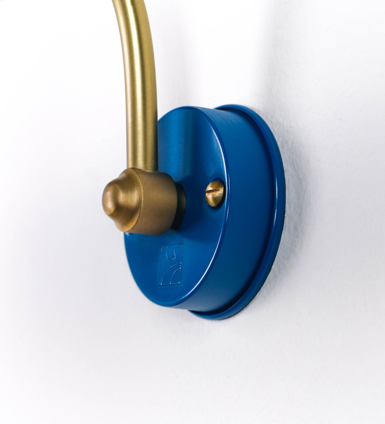Aplique de parede que combina elementos clássicos com toques contemporâneos. O aplique é composto por uma base circular azul vintage de onde se estende um braço curvo e gracioso, em latão escovado, que suporta a barra principal. O braço contém um elemento, em latão escovado, que permite apertar ou desapertar a barra para melhor manipular a direção da luz. A barra de 45cm de largura, é cilíndrica e alongada, azul vintage. As extremidades do cilindro são planas e do mesmo diâmetro.