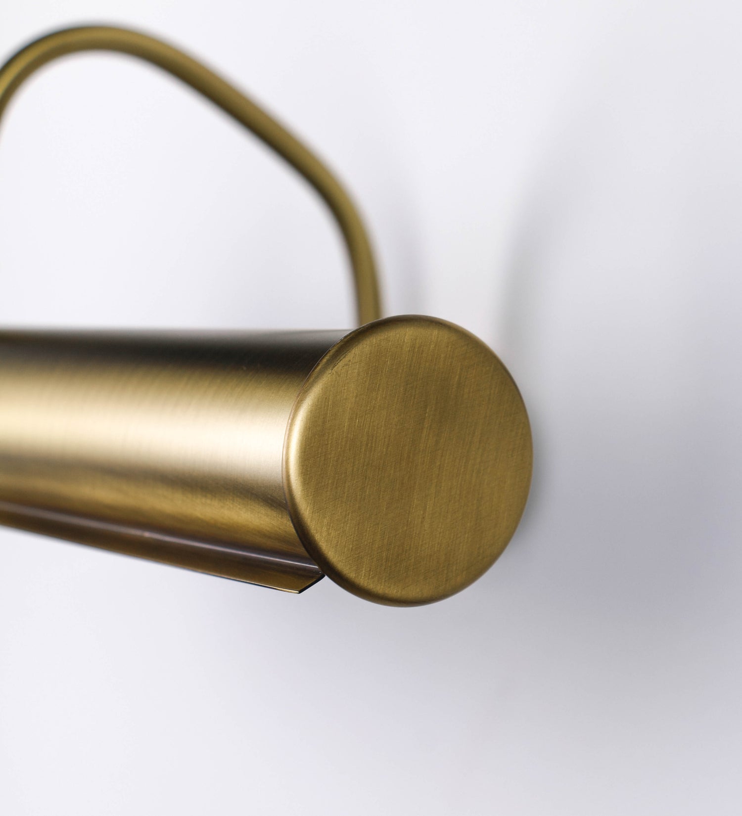 Aplique de parede que combina elementos clássicos com toques contemporâneos, todo em ouro velho. O aplique é composto por uma base circular de onde se estende um braço curvo e gracioso, que suporta a barra principal. O braço contém um elemento que permite apertar ou desapertar a barra para melhor manipular a direção da luz. A barra de 45cm de largura é cilíndrica e alongada. As extremidades do cilindro são planas e do mesmo diâmetro.