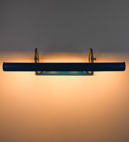 Aplique de parede que combina elementos clássicos com toques contemporâneos. O aplique é composto por uma base retangular azul vintage, de onde se estendem dois braços curvos e graciosos, em latão escovado, que suportam a barra principal. Os braços contêm um elemento, em latão escovado, que permite apertar ou desapertar a barra para melhor manipular a direção da luz. A barra de 65cm de largura, é cilíndrica e alongada, azul vintage. As extremidades do cilindro são planas e do mesmo diâmetro.