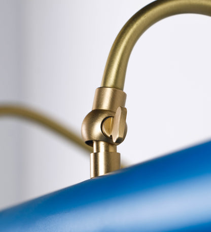 Aplique de parede que combina elementos clássicos com toques contemporâneos. O aplique é composto por uma base retangular azul vintage, de onde se estendem dois braços curvos e graciosos, em latão escovado, que suportam a barra principal. Os braços contêm um elemento, em latão escovado, que permite apertar ou desapertar a barra para melhor manipular a direção da luz. A barra de 65cm de largura, é cilíndrica e alongada, azul vintage. As extremidades do cilindro são planas e do mesmo diâmetro.