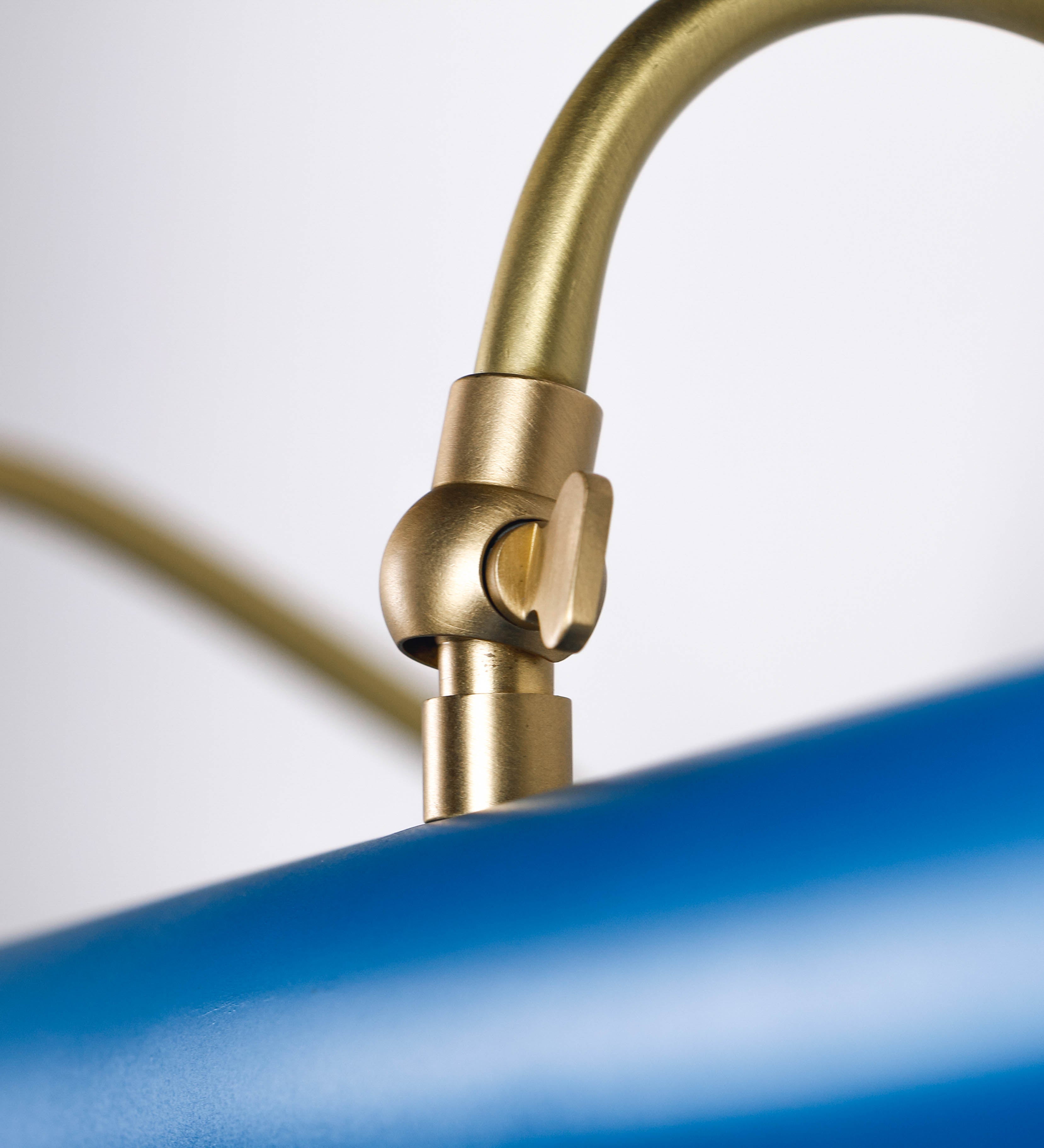 Aplique de parede que combina elementos clássicos com toques contemporâneos. O aplique é composto por uma base retangular azul vintage, de onde se estendem dois braços curvos e graciosos, em latão escovado, que suportam a barra principal. Os braços contêm um elemento, em latão escovado, que permite apertar ou desapertar a barra para melhor manipular a direção da luz. A barra de 65cm de largura, é cilíndrica e alongada, azul vintage. As extremidades do cilindro são planas e do mesmo diâmetro.