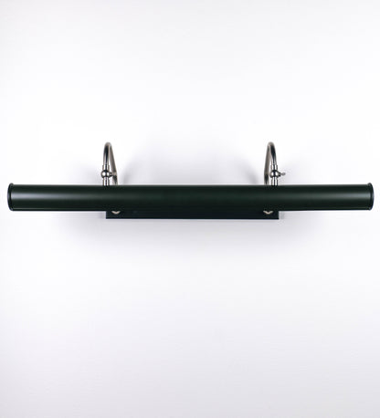 Aplique de parede que combina elementos clássicos com toques contemporâneos. O aplique é composto por uma base retangular verde-azeitona, de onde se estendem dois braços curvos e graciosos, em níquel escovado, que suportam a barra principal. Os braços contêm um elemento, em níquel escovado, que permite apertar ou desapertar a barra para melhor manipular a direção da luz. A barra de 65cm largura, é cilíndrica e alongada, tom vinho. As extremidades do cilindro são planas e do mesmo diâmetro.
