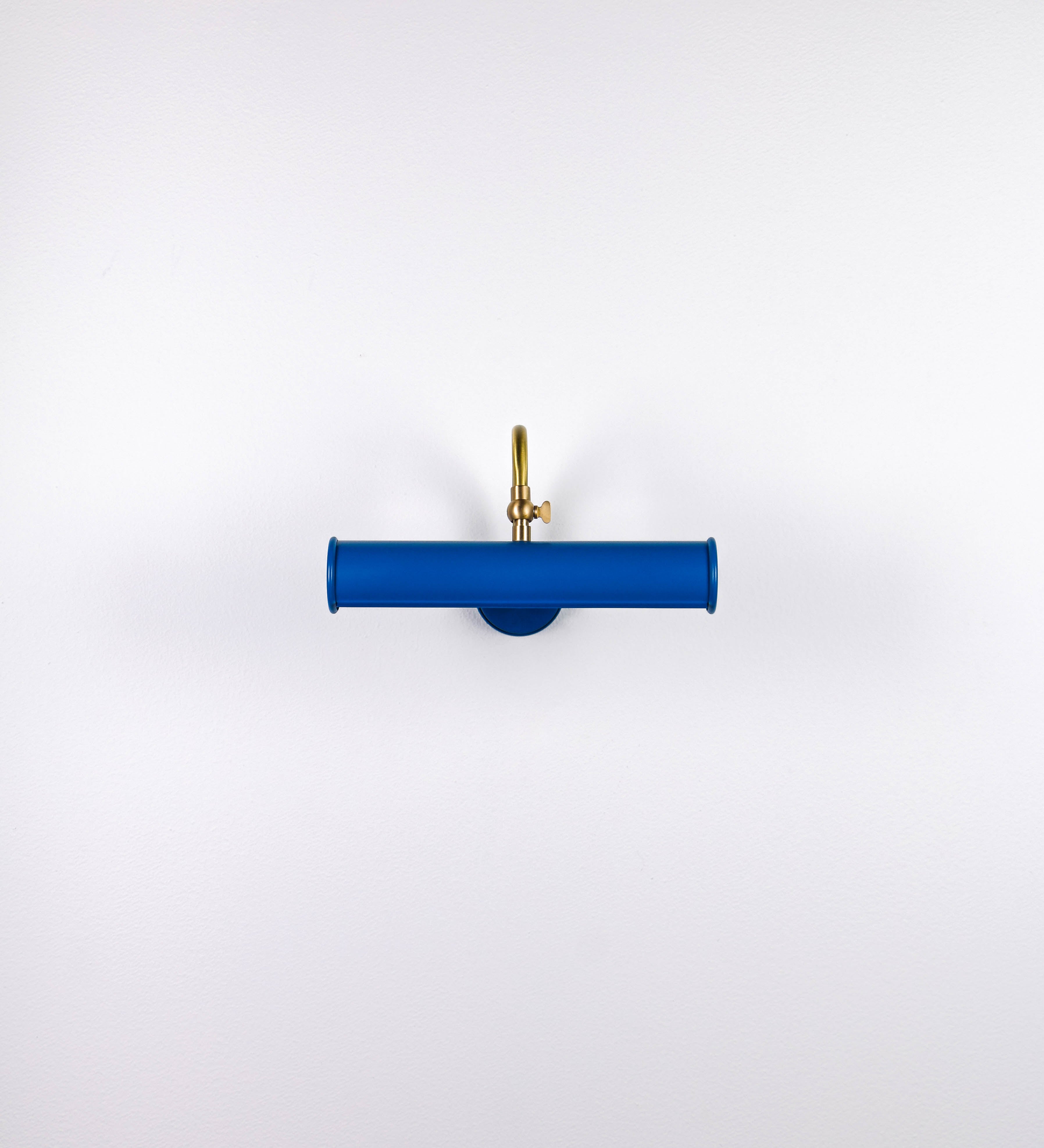Aplique de parede que combina elementos clássicos com toques contemporâneos. O aplique é composto por uma base circular azul vintage de onde se estende um braço curvo e gracioso, em latão escovado, que suporta a barra principal. O braço contém um elemento, em latão escovado, que permite apertar ou desapertar a barra para melhor manipular a direção da luz. A barra de 25cm de largura, é cilíndrica e alongada, azul vintage. As extremidades do cilindro são planas e do mesmo diâmetro.