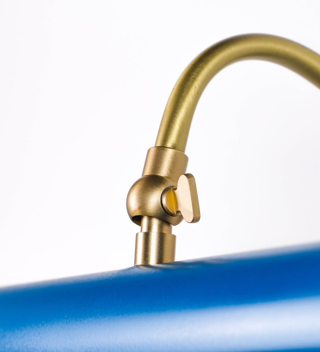 Aplique de parede que combina elementos clássicos com toques contemporâneos. O aplique é composto por uma base circular azul vintage de onde se estende um braço curvo e gracioso, em latão escovado, que suporta a barra principal. O braço contém um elemento, em latão escovado, que permite apertar ou desapertar a barra para melhor manipular a direção da luz. A barra de 25cm de largura, é cilíndrica e alongada, azul vintage. As extremidades do cilindro são planas e do mesmo diâmetro.