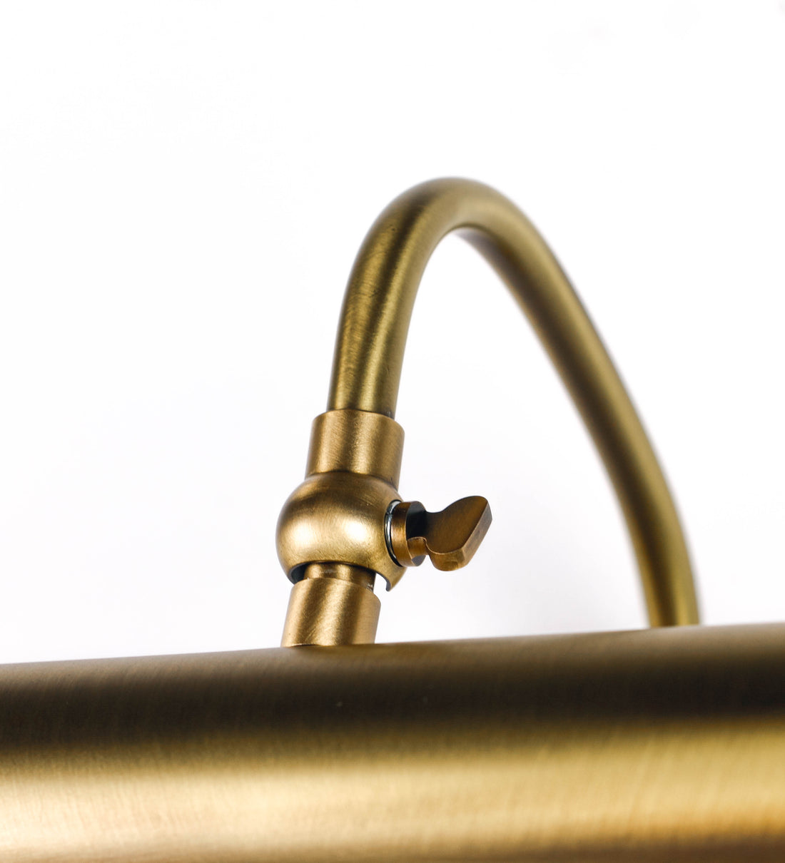 Aplique de parede que combina elementos clássicos com toques contemporâneos, todo em ouro velho. O aplique é composto por uma base circular de onde se estende um braço curvo e gracioso, que suporta a barra principal. O braço contém um elemento que permite apertar ou desapertar a barra para melhor manipular a direção da luz. A barra de 25cm de largura é cilíndrica e alongada. As extremidades do cilindro são planas e do mesmo diâmetro.
