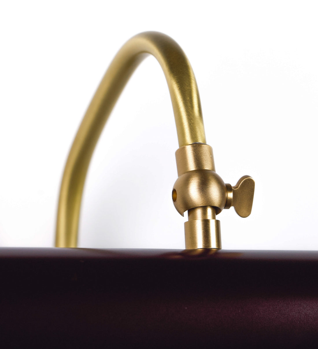 Aplique de parede que combina elementos clássicos com toques contemporâneos. O aplique é composto por uma base circular tom vinho, de onde se estende um braço curvo e gracioso, em latão escovado, que suporta a barra principal. O braço contém um elemento, em latão escovado, que permite apertar ou desapertar a barra para melhor manipular a direção da luz. A barra de 25cm de largura, é cilíndrica e alongada, tom vinho. As extremidades do cilindro são planas e do mesmo diâmetro.