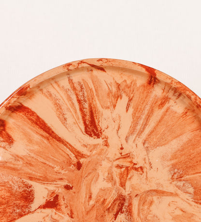 Prato de aperitivos com design minimalista e distinto. O prato é de barro, com uma mistura dois tipos de barro diferentes, um mais escuro e outro mais claro. Esta mistura cria um desenho de formas abstratas e aleatórias, que se espalham por todas as superfícies do prato. Tem um acabamento vidrado transparente com brilho, conferindo um toque de sofisticação e preservando os tons naturais dos barros. A forma do prato é circular, com uma borda envolvente de altura baixa e design simples e minimalista. 