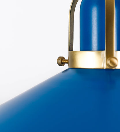 Suspensão de teto composta por uma base circular azul vintage de onde desce um cabo com padrão de linhas azuis e beges. O cabo passa por uma roldana em latão escovado fixa ao teto, e desce até ao chapéu. Entre a base e a roldana o cabo sustenta uma esfera em latão escovado, que atua como um contrapeso, para ajustar a altura. O chapéu, azul vintage, tem formato cónico invertido, uma borda ligeiramente levantada e interior branco. No topo do chapéu há um suporte em latão escovado que conecta o chapéu ao cabo.
