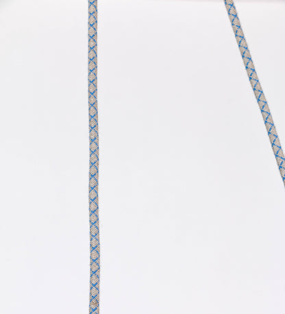 Suspensão de teto composta por uma base circular azul vintage de onde desce um cabo com padrão de linhas azuis e beges. O cabo passa por uma roldana em latão escovado fixa ao teto, e desce até ao chapéu. Entre a base e a roldana o cabo sustenta uma esfera em latão escovado, que atua como um contrapeso, para ajustar a altura. O chapéu, azul vintage, tem formato cónico invertido, uma borda ligeiramente levantada e interior branco. No topo do chapéu há um suporte em latão escovado que conecta o chapéu ao cabo.