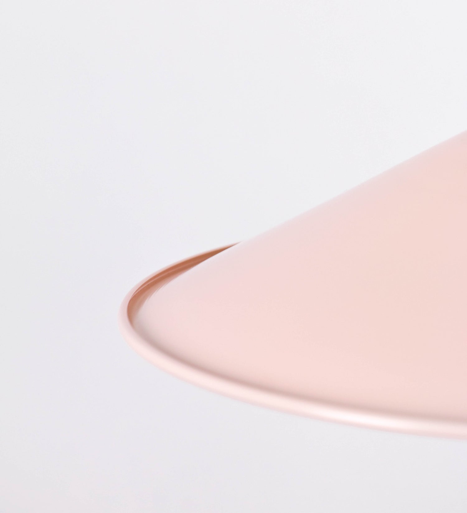 Suspensão de teto composta por uma base circular rosa clara, de onde desce um cabo revestido têxtil rosa velho. O cabo passa por uma roldana em níquel polido, fixa ao teto, e desce até ao chapéu. Entre a base e a roldana, o cabo sustenta uma esfera, em níquel polido, que atua como um contrapeso, para ajustar a altura. O chapéu, rosa claro, tem formato cónico invertido, uma borda ligeiramente levantada e interior branco. No topo do chapéu, há um suporte em níquel polido que conecta o chapéu ao cabo.