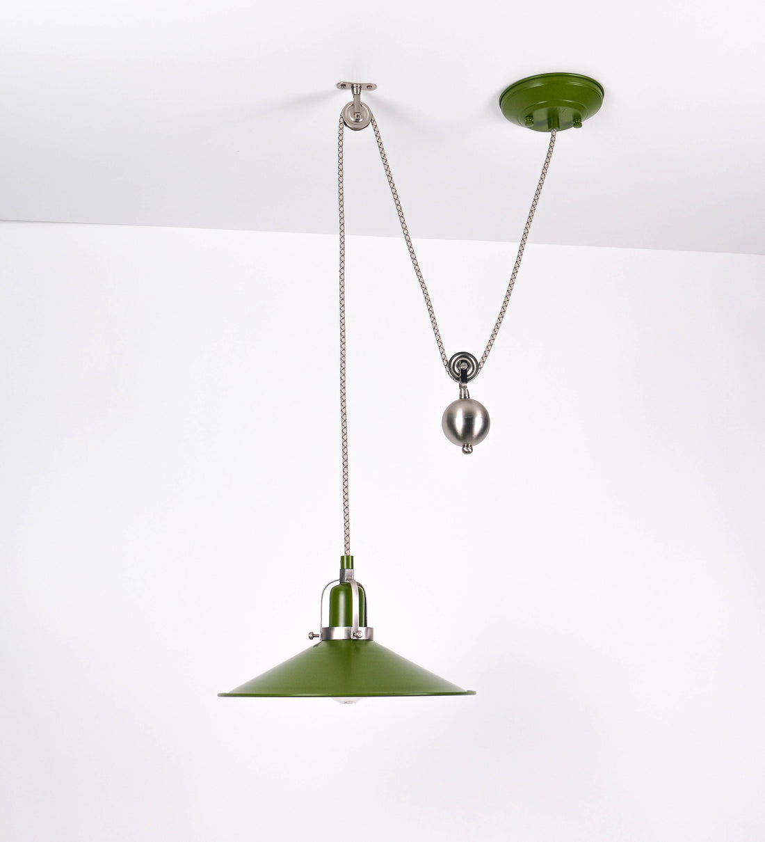 Suspensão de teto composta por uma base circular verde couve-de-bruxelas de onde desce um cabo com padrão de linhas castanhas e beges. O cabo passa por uma roldana em níquel escovado fixa ao teto, e desce até ao chapéu. Entre a base e a roldana o cabo sustenta uma esfera em níquel escovado, que atua como um contrapeso, para ajustar a altura. O chapéu é verde, de formato cónico invertido, uma borda levantada e interior branco. No topo do chapéu há um suporte em níquel escovado que conecta o chapéu ao cabo.