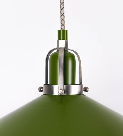Suspensão de teto composta por uma base circular verde couve-de-bruxelas de onde desce um cabo com padrão de linhas castanhas e beges. O cabo passa por uma roldana em níquel escovado fixa ao teto, e desce até ao chapéu. Entre a base e a roldana o cabo sustenta uma esfera em níquel escovado, que atua como um contrapeso, para ajustar a altura. O chapéu é verde, de formato cónico invertido, uma borda levantada e interior branco. No topo do chapéu há um suporte em níquel escovado que conecta o chapéu ao cabo.