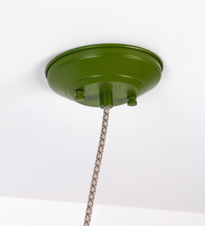 Suspensão de teto composta por uma base circular verde couve-de-bruxelas de onde desce um cabo com padrão de linhas castanhas e beges. O cabo passa por uma roldana em níquel escovado fixa ao teto, e desce até ao chapéu. Entre a base e a roldana o cabo sustenta uma esfera em níquel escovado, que atua como um contrapeso, para ajustar a altura. O chapéu é verde, de formato cónico invertido, uma borda levantada e interior branco. No topo do chapéu há um suporte em níquel escovado que conecta o chapéu ao cabo.