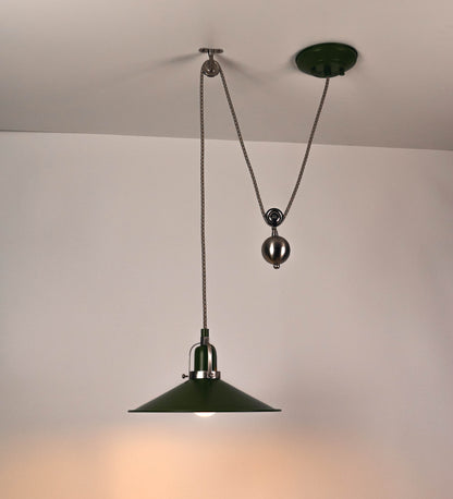Suspensão de teto composta por uma base circular verde couve-de-bruxelas de onde desce um cabo com padrão de linhas castanhas e beges. O cabo passa por uma roldana em níquel escovado fixa ao teto, e desce até ao chapéu. Entre a base e a roldana o cabo sustenta uma esfera em níquel escovado, que atua como um contrapeso, para ajustar a altura. O chapéu é verde, de formato cónico invertido, uma borda levantada e interior branco. No topo do chapéu há um suporte em níquel escovado que conecta o chapéu ao cabo.