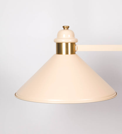 Suspensão de teto moderna e sofisticada. A suspensão é composta por uma base retangular em latão escovado, de onde desce um tubo cilíndrico até a estrutura principal e permite ajustar a altura da suspensão. A estrutura principal é composta por uma barra horizontal bege clara, que sustenta nas extremidades dois chapéus cónicos invertidos no mesmo tom, com interior em latão escovado. No centro da barra horizontal está uma pequena placa oval, em latão escovado, com o ano 1930 inscrito em relevo.