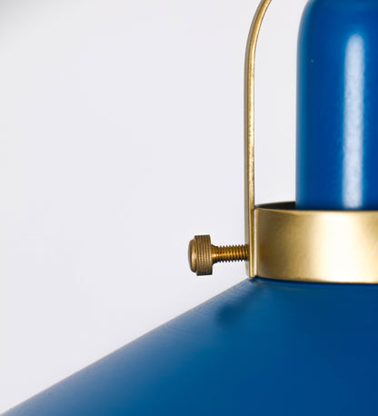 Suspensão de teto que combina um design clássico com cores modernas. A suspensão é fixa ao teto através de uma base circular azul vintage, de onde desce um cabo revestido têxtil com um padrão de linhas azuis e beges entrelaçadas, que sustenta o chapéu principal. O chapéu, azul vintage, tem um formato cónico invertido, com uma borda ligeiramente levantada. O interior do chapéu é branco. No topo do chapéu, há um suporte circular em latão escovado, com três pequenos braços que conecta o chapéu ao cabo.