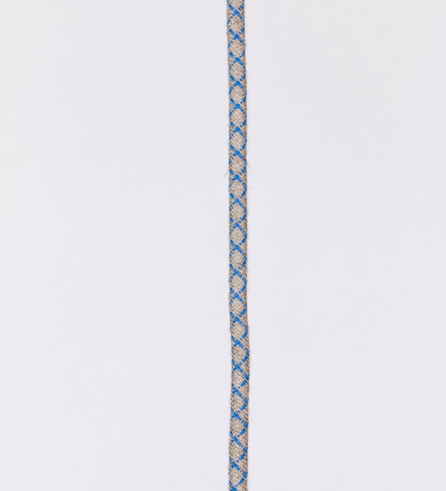 Suspensão de teto que combina um design clássico com cores modernas. A suspensão é fixa ao teto através de uma base circular azul vintage, de onde desce um cabo revestido têxtil com um padrão de linhas azuis e beges entrelaçadas, que sustenta o chapéu principal. O chapéu, azul vintage, tem um formato cónico invertido, com uma borda ligeiramente levantada. O interior do chapéu é branco. No topo do chapéu, há um suporte circular em latão escovado, com três pequenos braços que conecta o chapéu ao cabo.