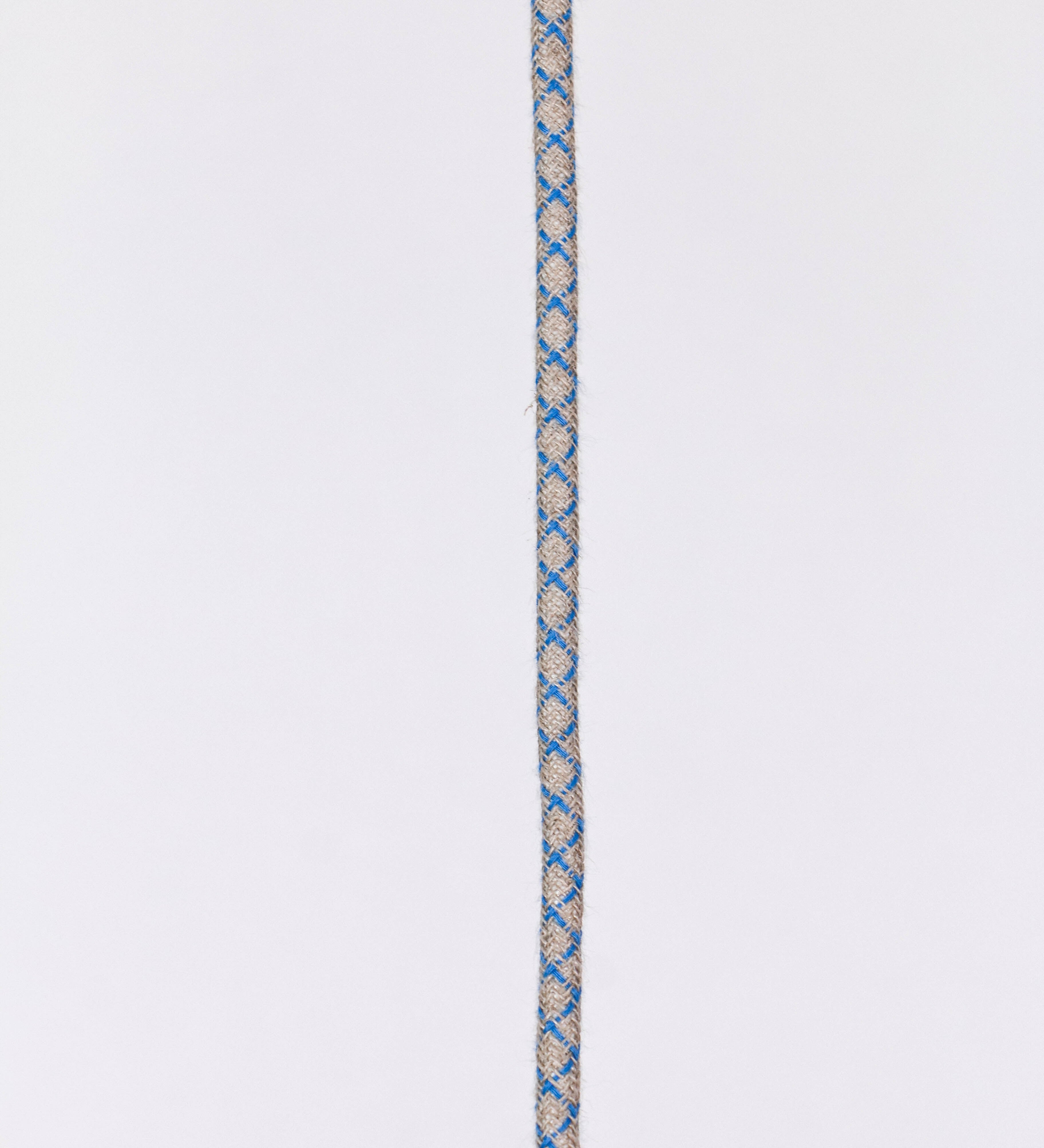 Suspensão de teto que combina um design clássico com cores modernas. A suspensão é fixa ao teto através de uma base circular azul vintage, de onde desce um cabo revestido têxtil com um padrão de linhas azuis e beges entrelaçadas, que sustenta o chapéu principal. O chapéu, azul vintage, tem um formato cónico invertido, com uma borda ligeiramente levantada. O interior do chapéu é branco. No topo do chapéu, há um suporte circular em latão escovado, com três pequenos braços que conecta o chapéu ao cabo.