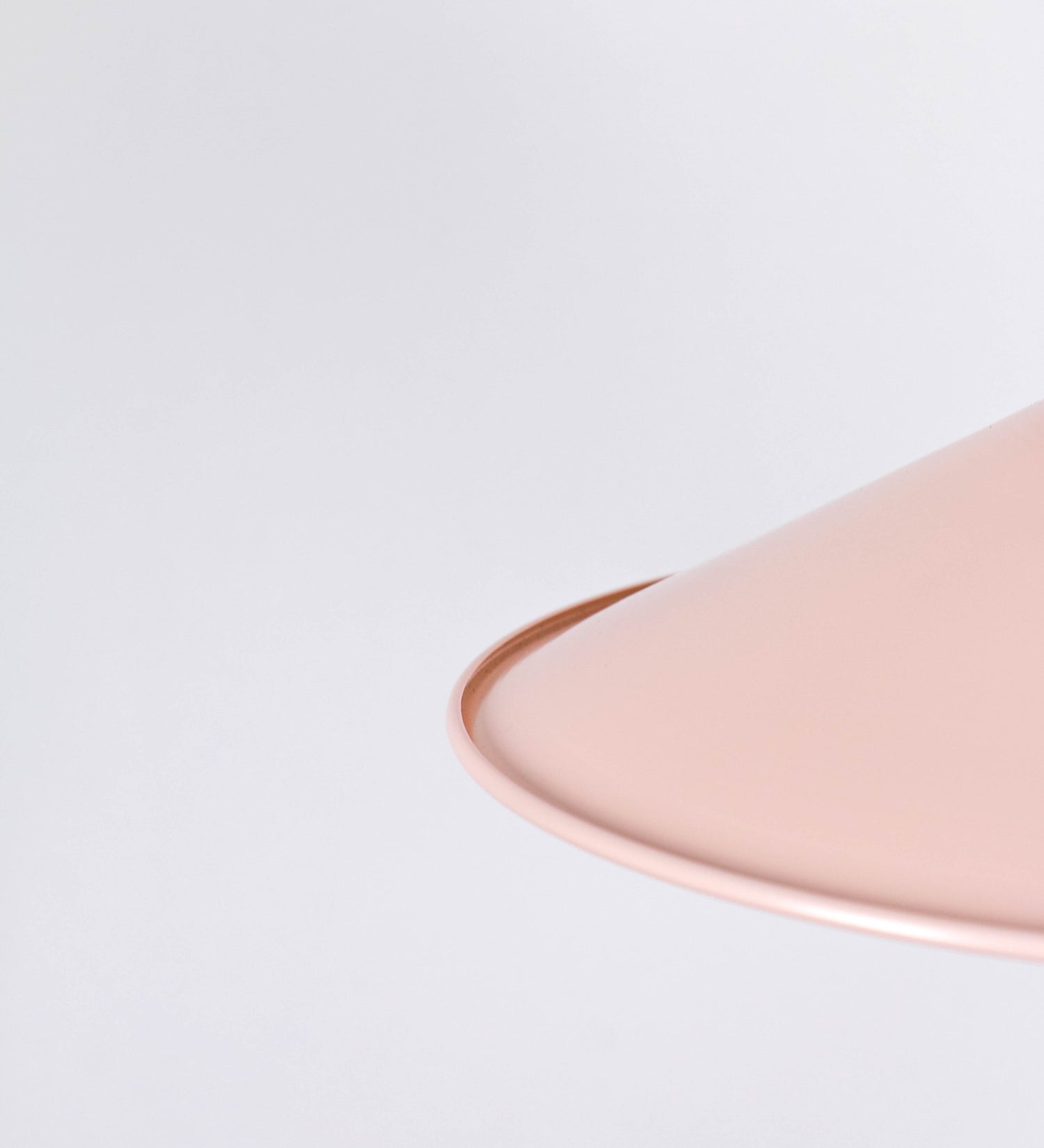 Suspensão de teto que combina um design clássico com cores modernas. A suspensão é fixa ao teto através de uma base circular rosa clara, de onde desce um cabo revestido têxtil rosa velho, que sustenta o chapéu principal. O chapéu, rosa claro, tem um formato cónico invertido, com uma borda ligeiramente levantada. O interior do chapéu é branco. No topo do chapéu, há um suporte circular em níquel polido, com três pequenos braços que conecta o chapéu ao cabo.