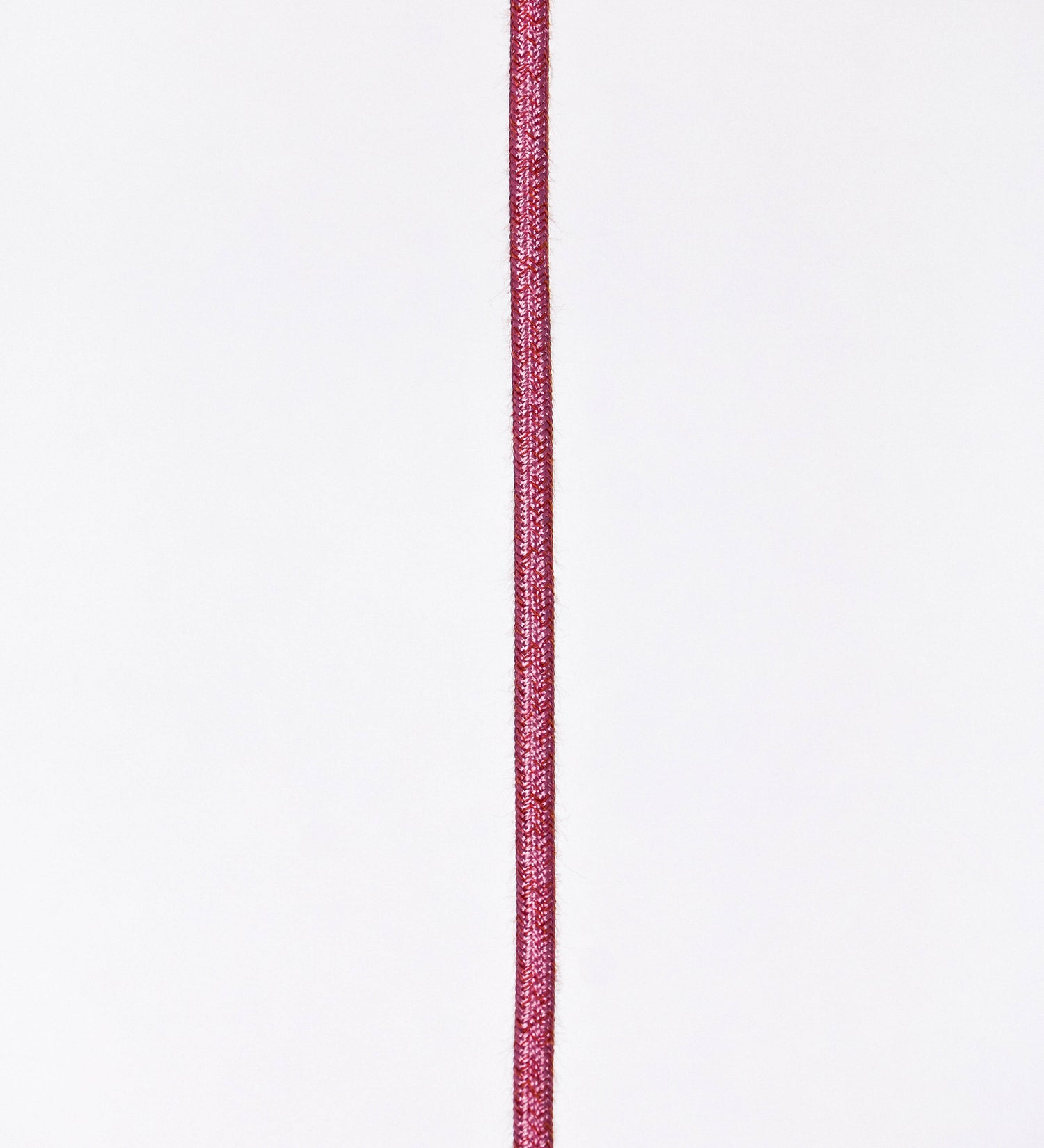 Suspensão de teto que combina um design clássico com cores modernas. A suspensão é fixa ao teto através de uma base circular rosa clara, de onde desce um cabo revestido têxtil rosa velho, que sustenta o chapéu principal. O chapéu, rosa claro, tem um formato cónico invertido, com uma borda ligeiramente levantada. O interior do chapéu é branco. No topo do chapéu, há um suporte circular em níquel polido, com três pequenos braços que conecta o chapéu ao cabo.