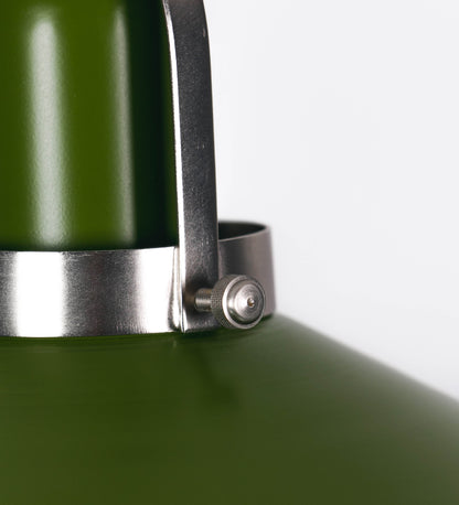 Suspensão de teto que combina um design clássico e cores modernas. A suspensão é fixa ao teto através de uma base circular verde couve-de-bruxelas, de onde desce um cabo revestido têxtil com um padrão de linhas castanhas e beges entrelaçadas, que sustenta o chapéu principal. O chapéu, verde, tem um formato cónico invertido, com uma borda ligeiramente levantada. O interior do chapéu é branco. No topo do chapéu, há um suporte circular em níquel escovado, com três pequenos braços que conecta o chapéu ao cabo.