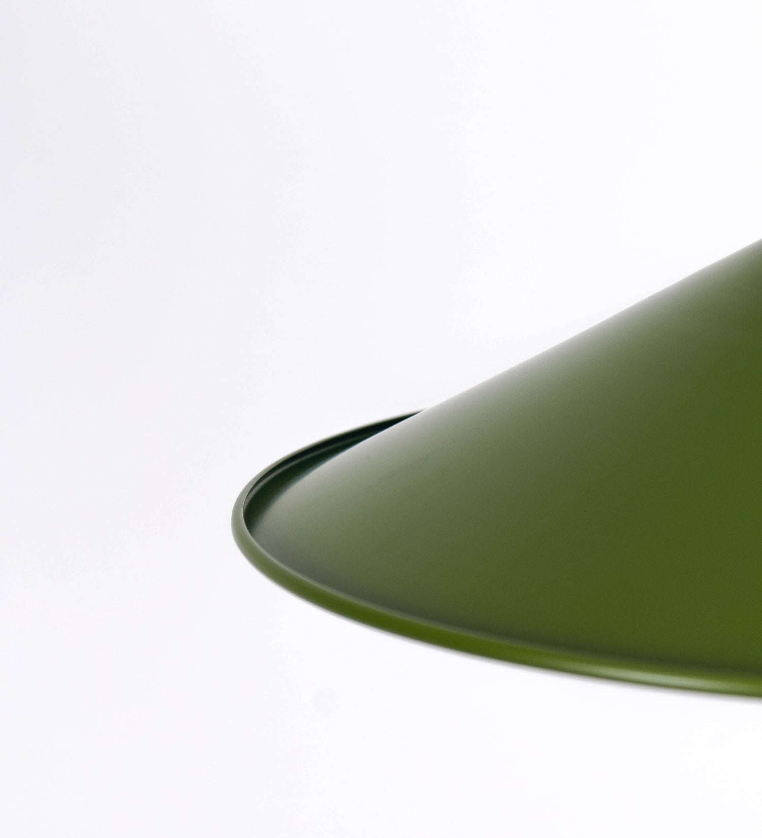 Suspensão de teto que combina um design clássico e cores modernas. A suspensão é fixa ao teto através de uma base circular verde couve-de-bruxelas, de onde desce um cabo revestido têxtil com um padrão de linhas castanhas e beges entrelaçadas, que sustenta o chapéu principal. O chapéu, verde, tem um formato cónico invertido, com uma borda ligeiramente levantada. O interior do chapéu é branco. No topo do chapéu, há um suporte circular em níquel escovado, com três pequenos braços que conecta o chapéu ao cabo.